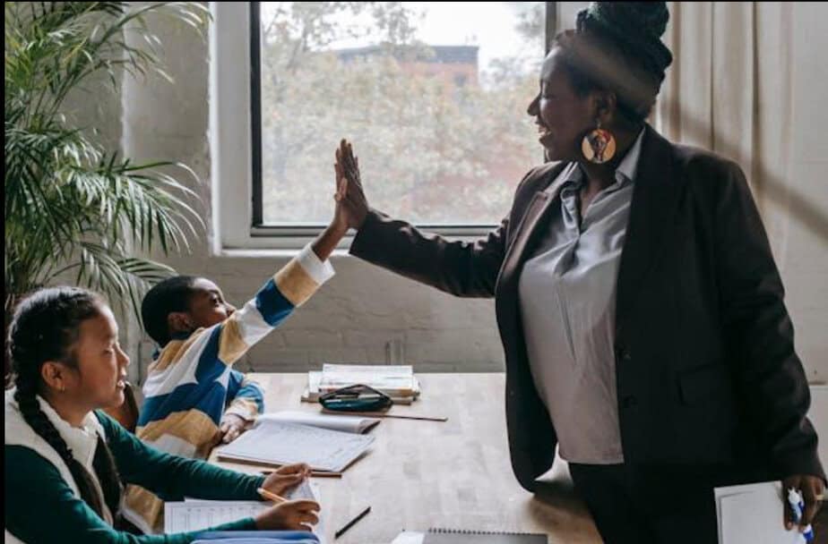 A teacher giving a high-five to a student.
