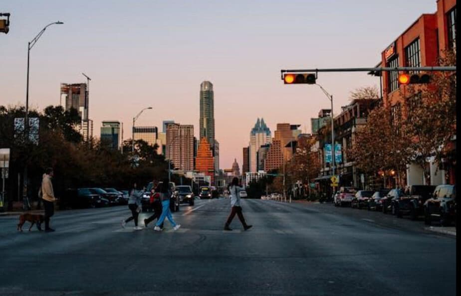 People crossing a street in Austin with buildings in the background