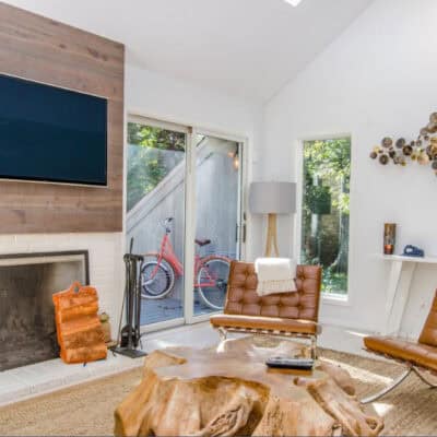 two tufted brown leather chairs in front of brown wood stump center table