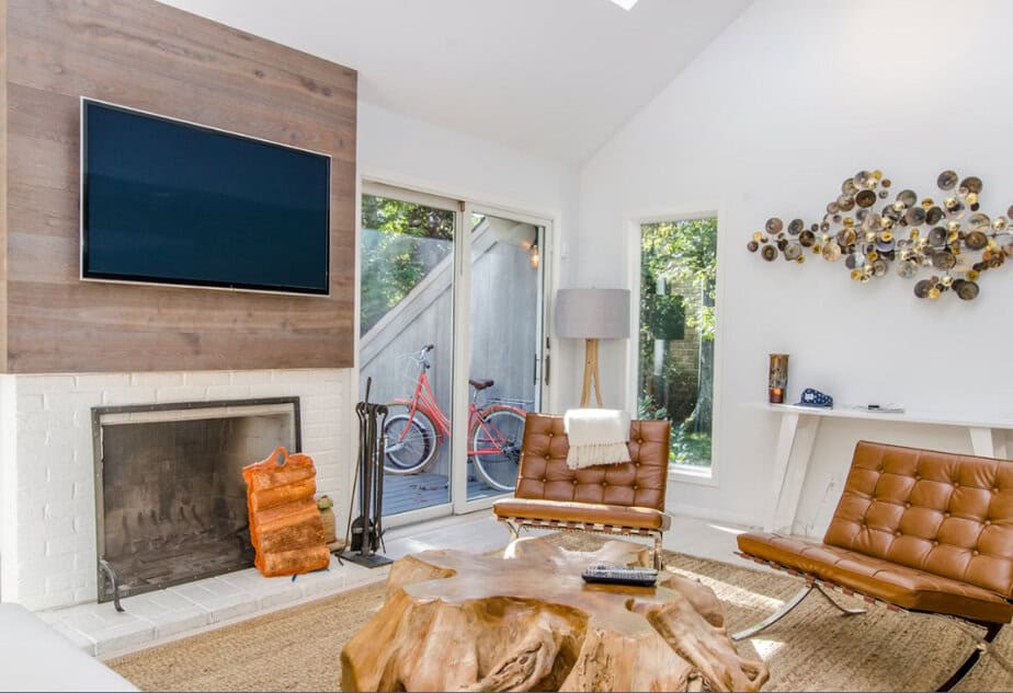 two tufted brown leather chairs in front of brown wood stump center table